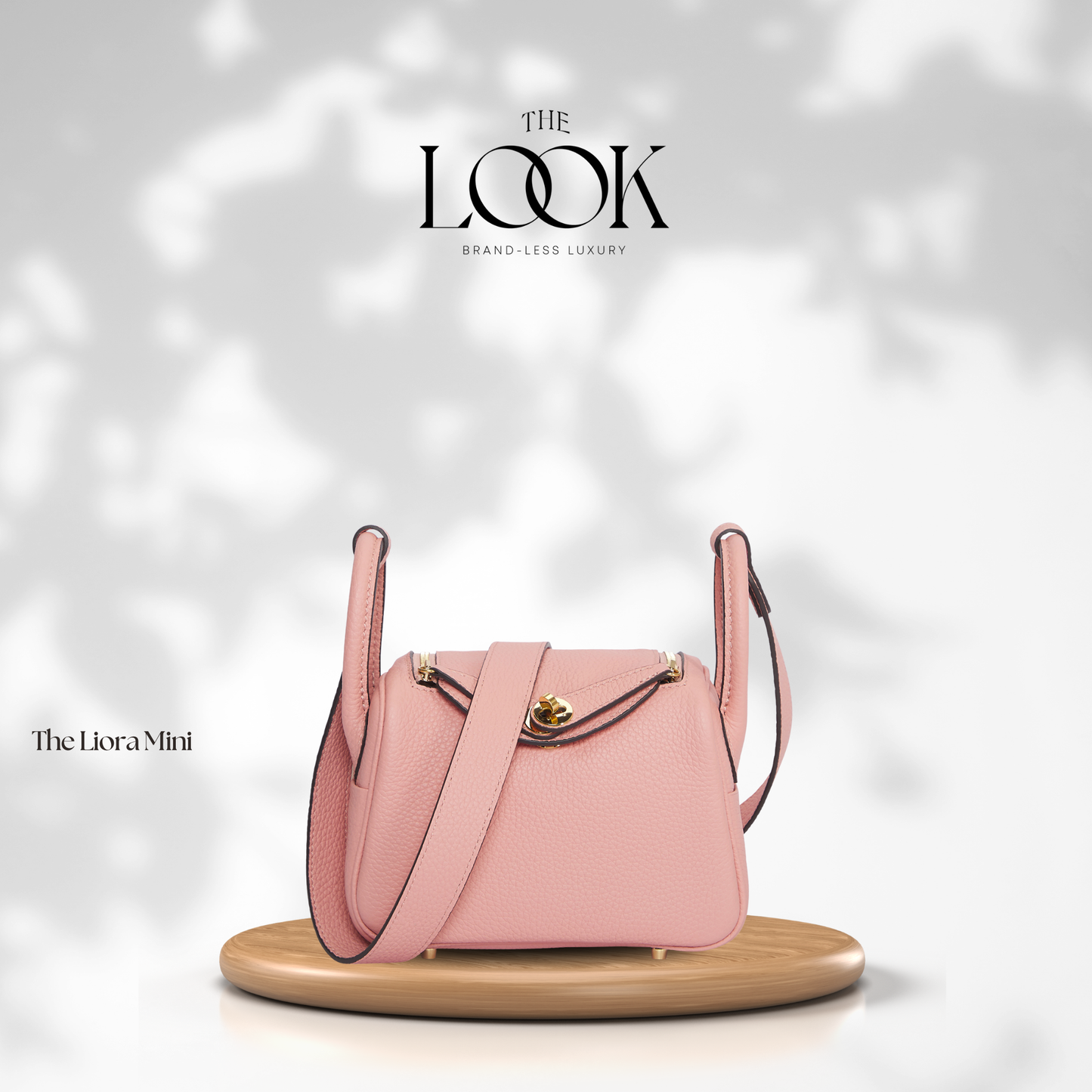 Pink handbag on a wooden stand with 'The Look' branding on a soft white background | The Look Officiel