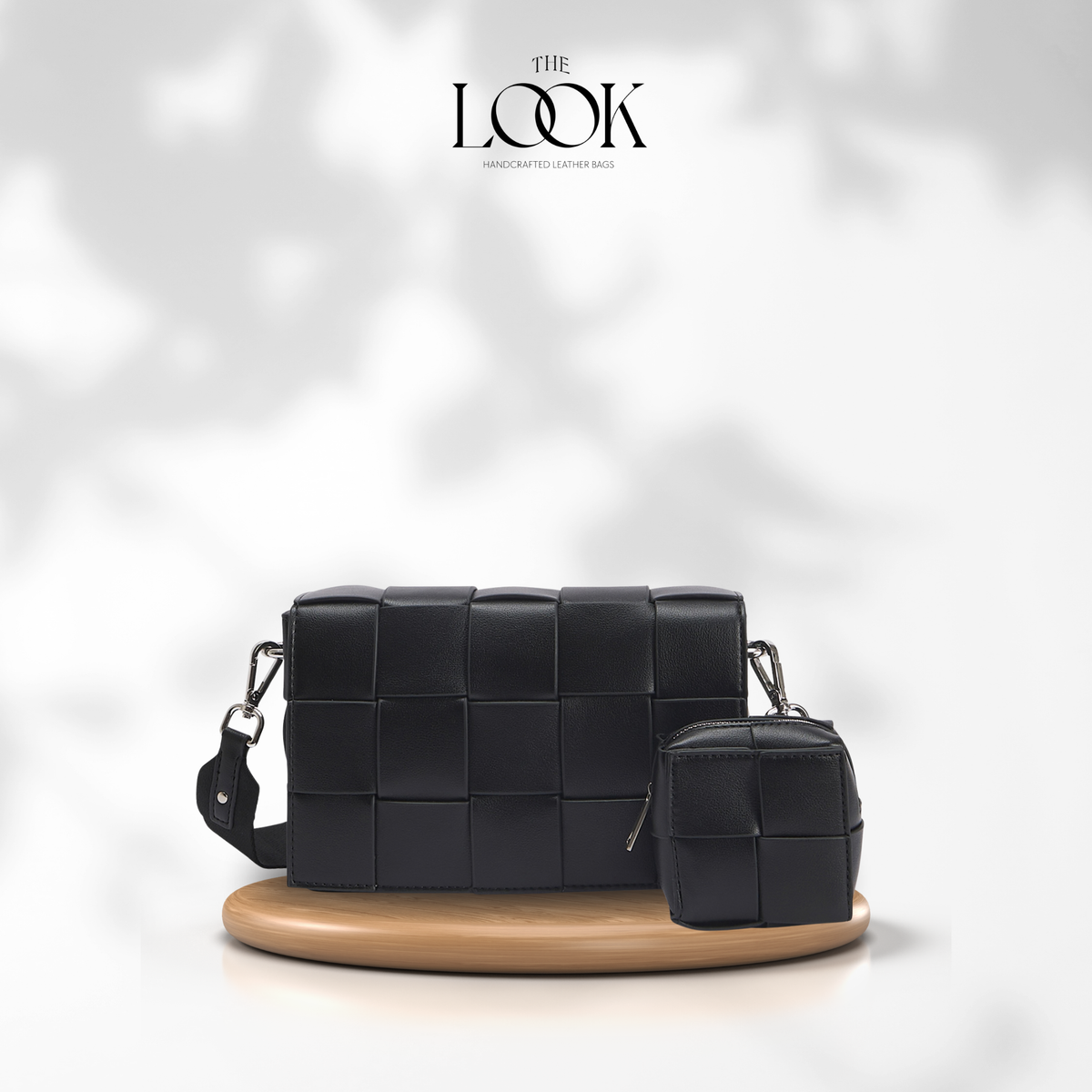 Black Loop Grid Extra woven leather crossbody bag with matching removable pouch on wooden display | The Look Officiel