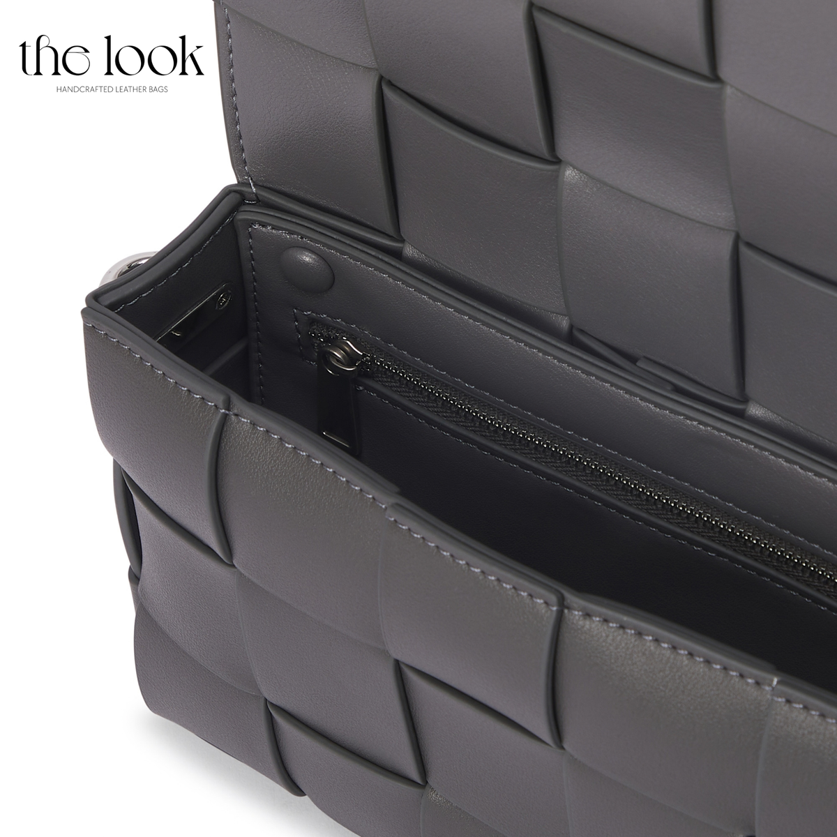 Close-up of gray Loop Grid Extra leather bag interior showing zippered pocket and woven detailing | The Look Officiel
