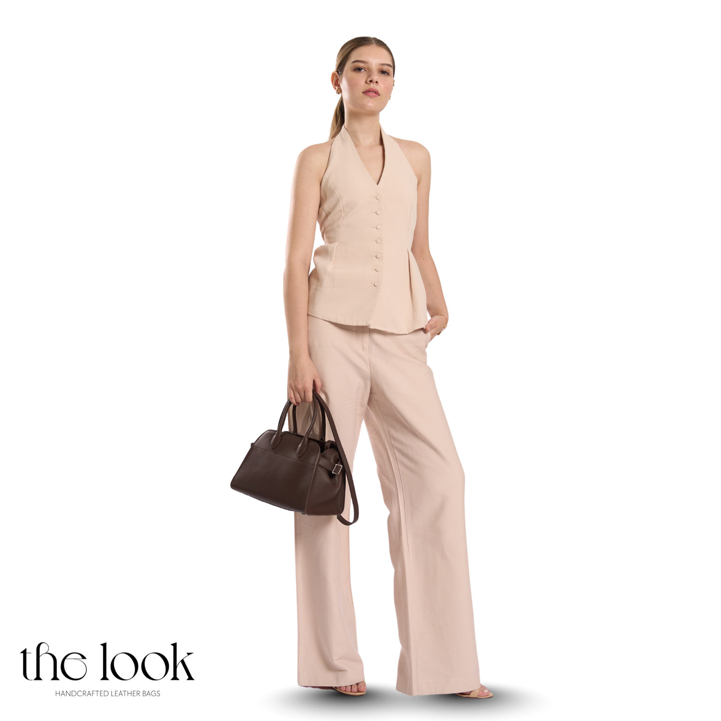 Woman in a beige outfit holding a brown handbag on a white background with 'the look' branding. | The Look Officiel