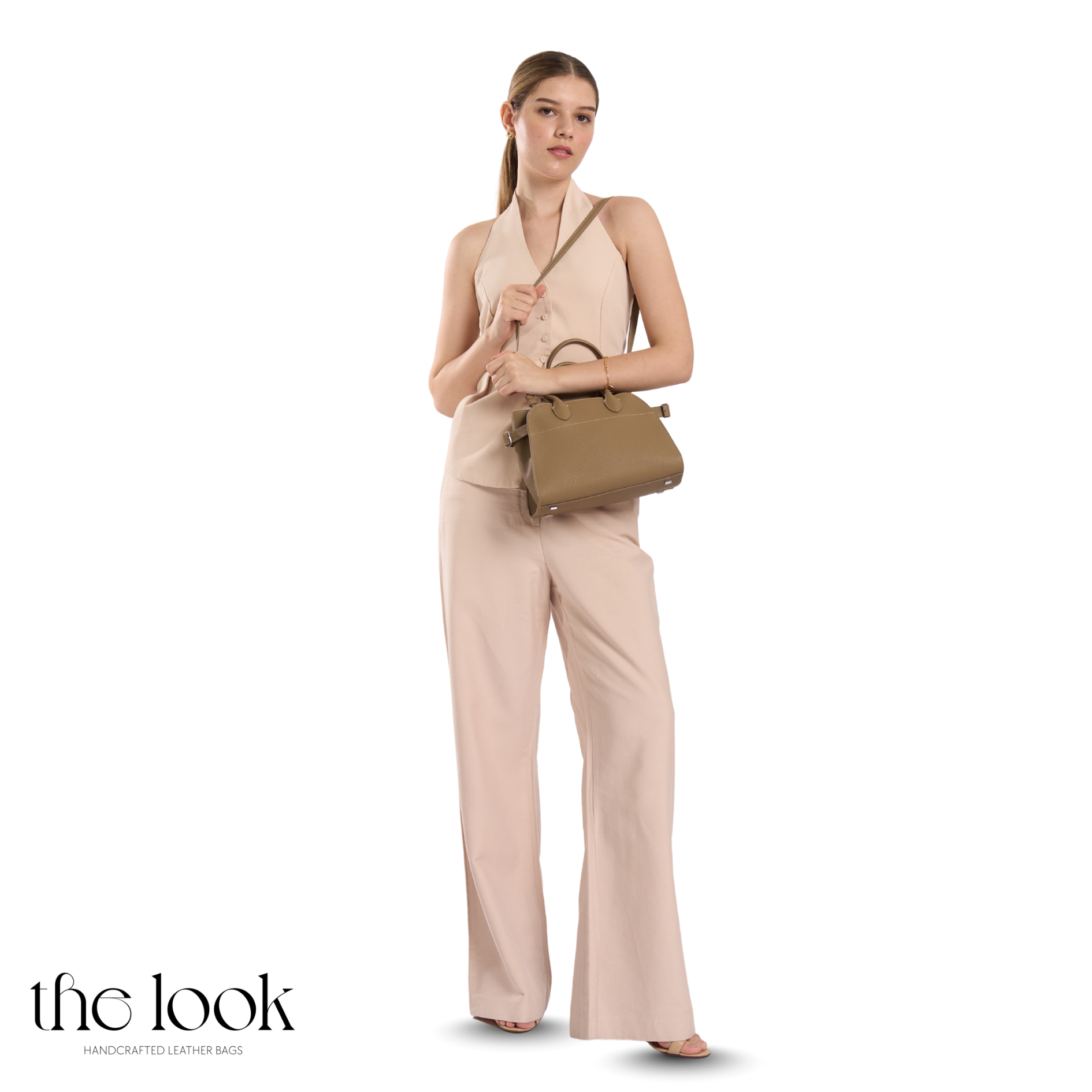 Woman in a beige outfit holding a brown handbag on a white background with 'the look' branding. | The Look Officiel