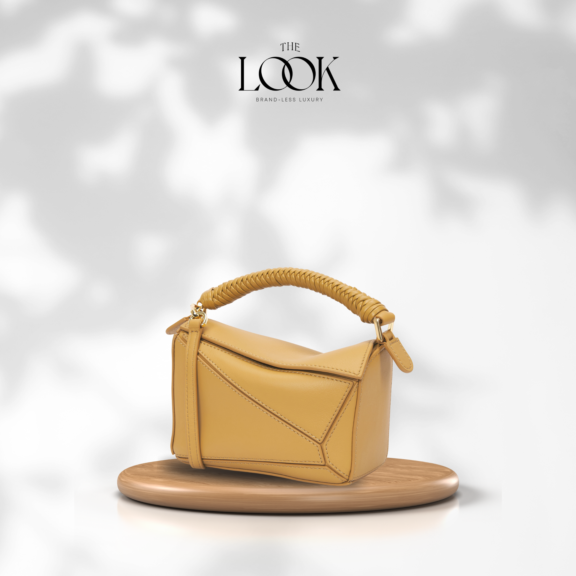 Yellow handbag with braided handle on a white background, featuring 'The Look' brand. | The Look Officiel
