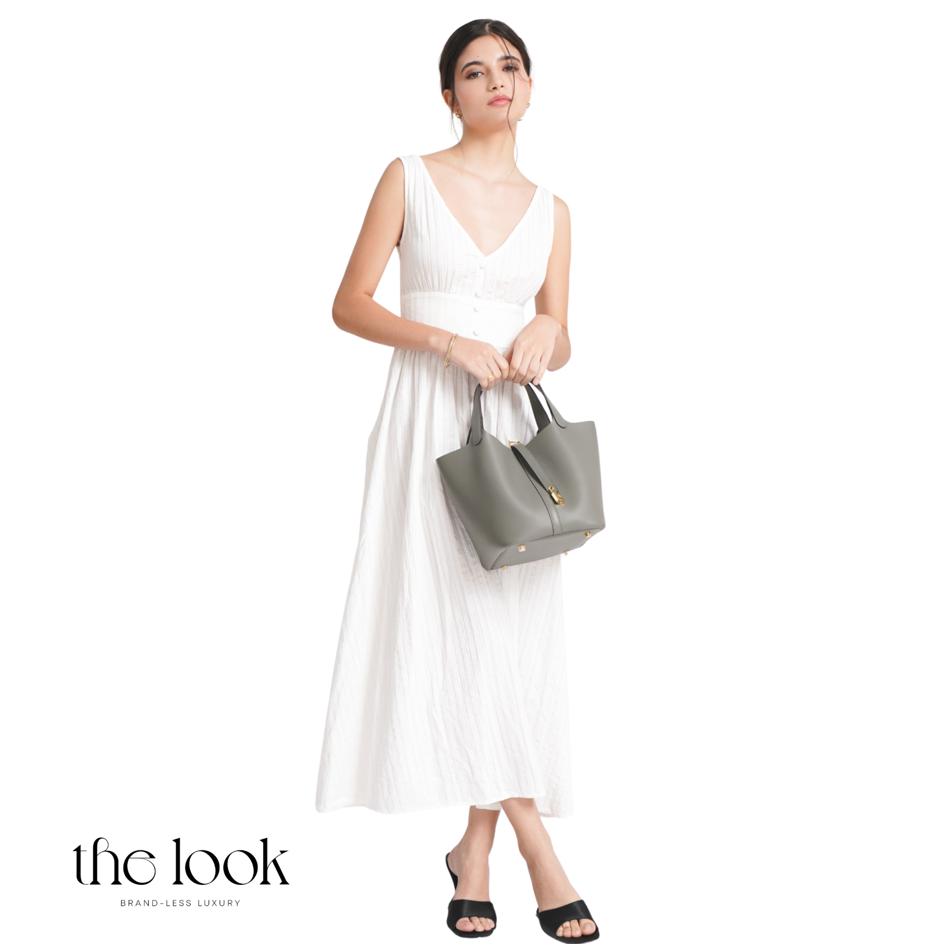 Woman in a white dress holding a gray handbag on a white background with 'the look' branding. | The Look Officiel