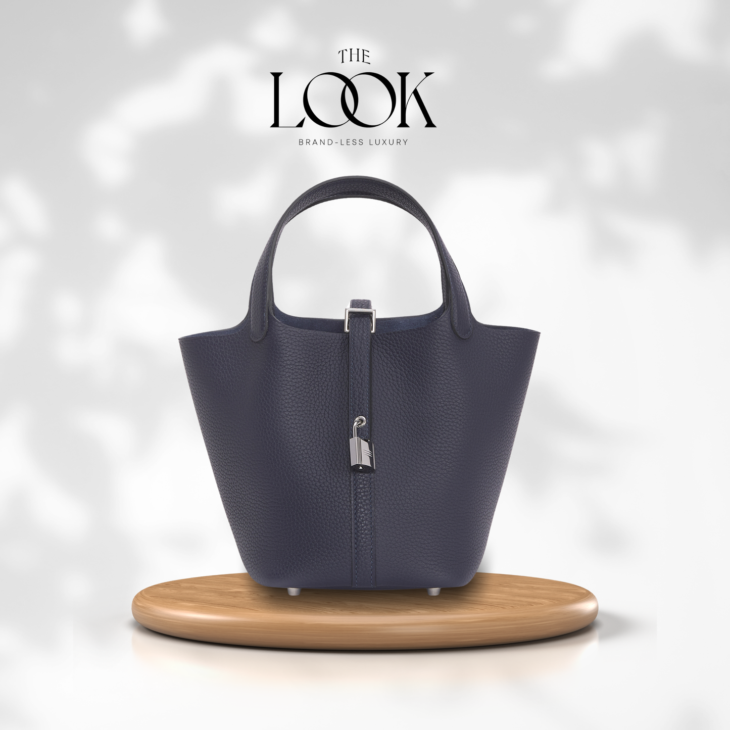Blue handbag on a wooden stand with 'The Look' branding on a light gray background | The Look Officiel
