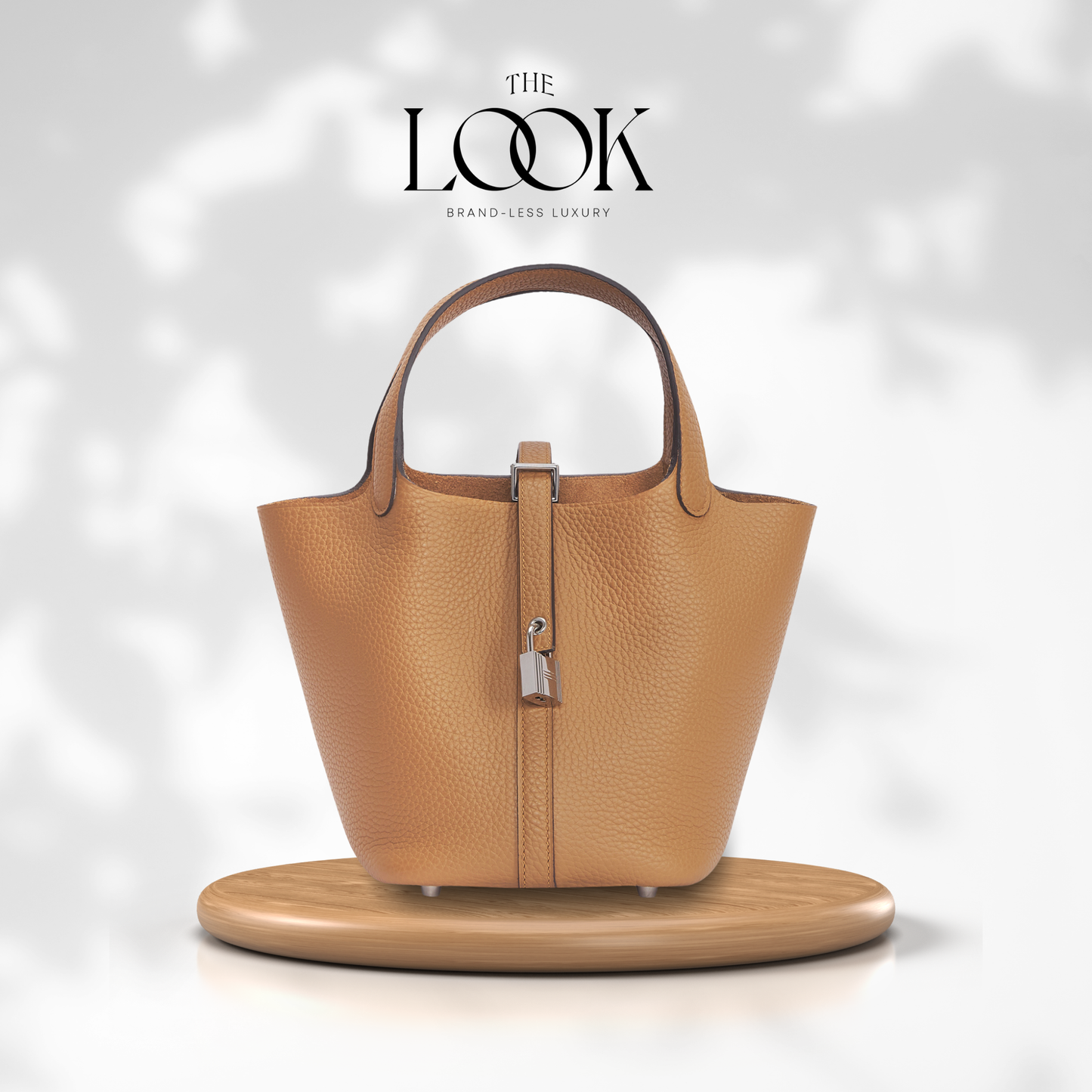 Tan handbag on a wooden stand with 'The Look' branding on a light gray background | The Look Officiel