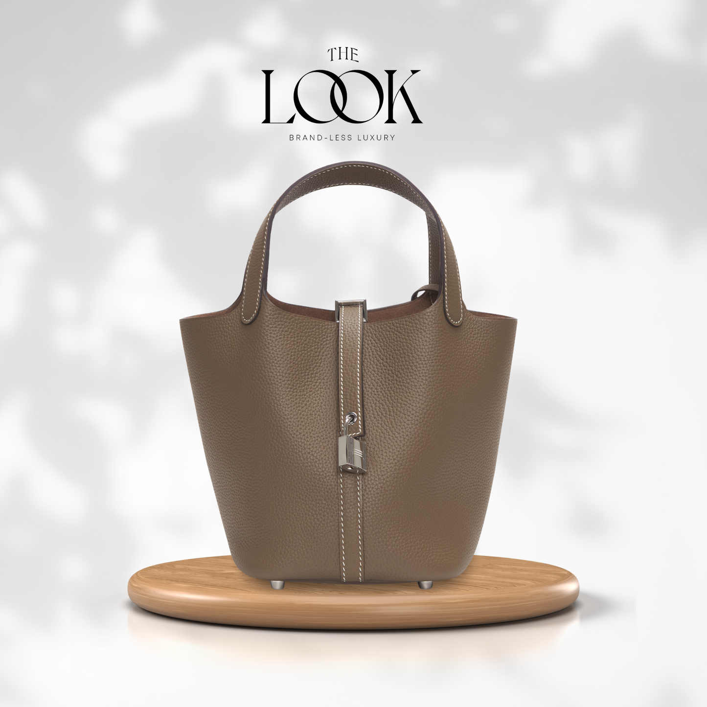 Brown handbag on a wooden stand with 'The Look' branding on a light gray background | The Look Officiel