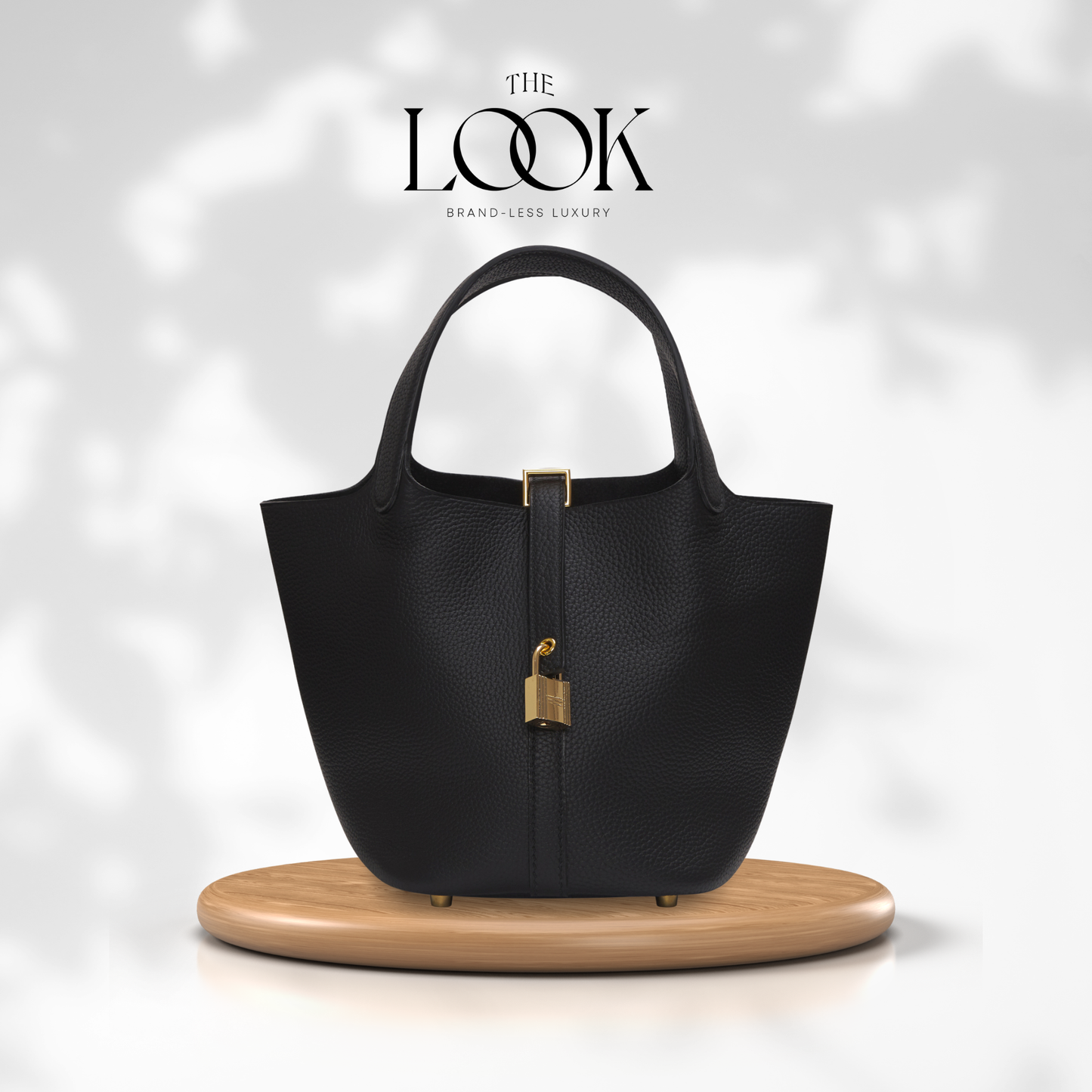 Black handbag with gold accents on a wooden stand, branded 'The Look'. | The look Officiel