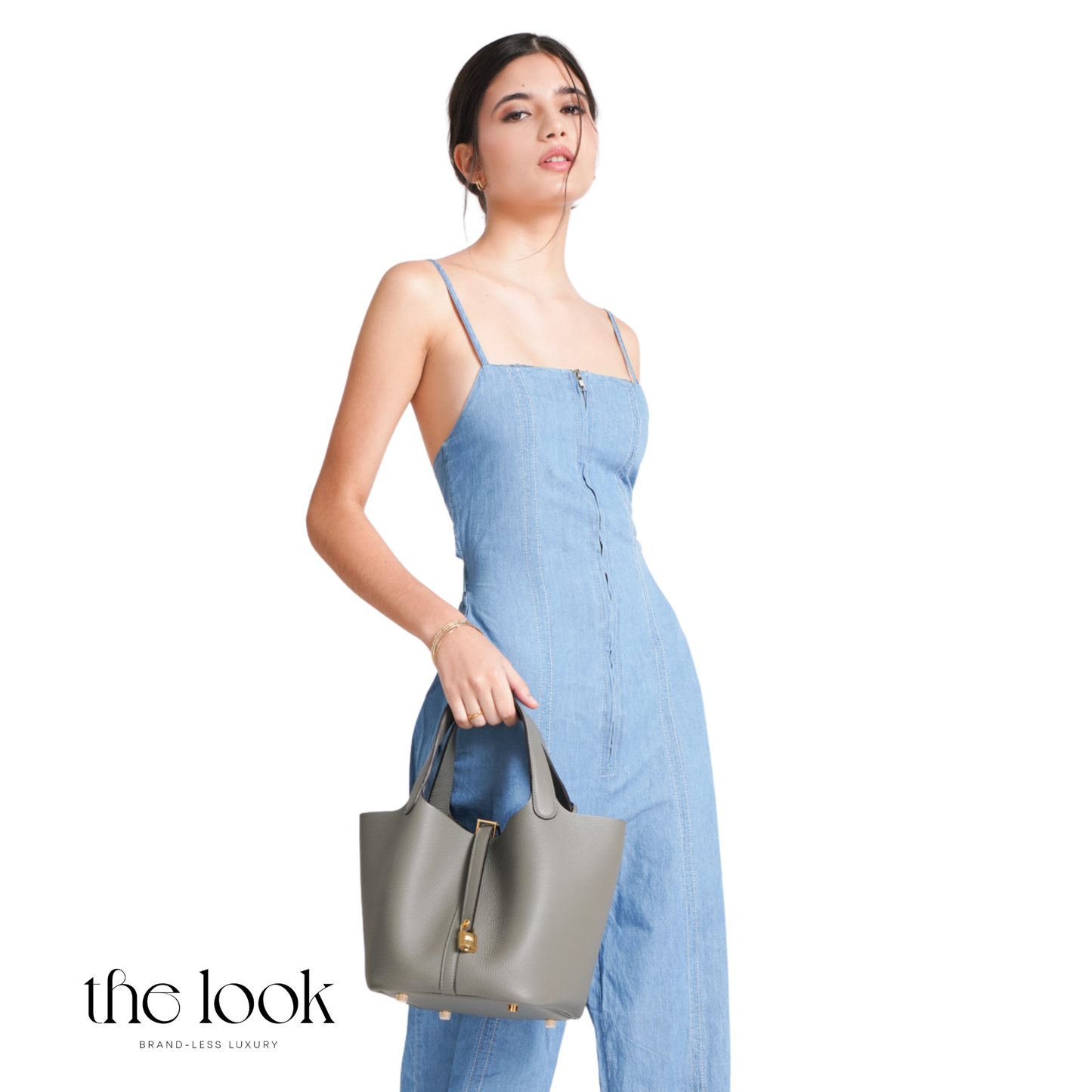 Woman in a blue dress holding a gray handbag on a white background with 'the look' branding. | The Look Officiel