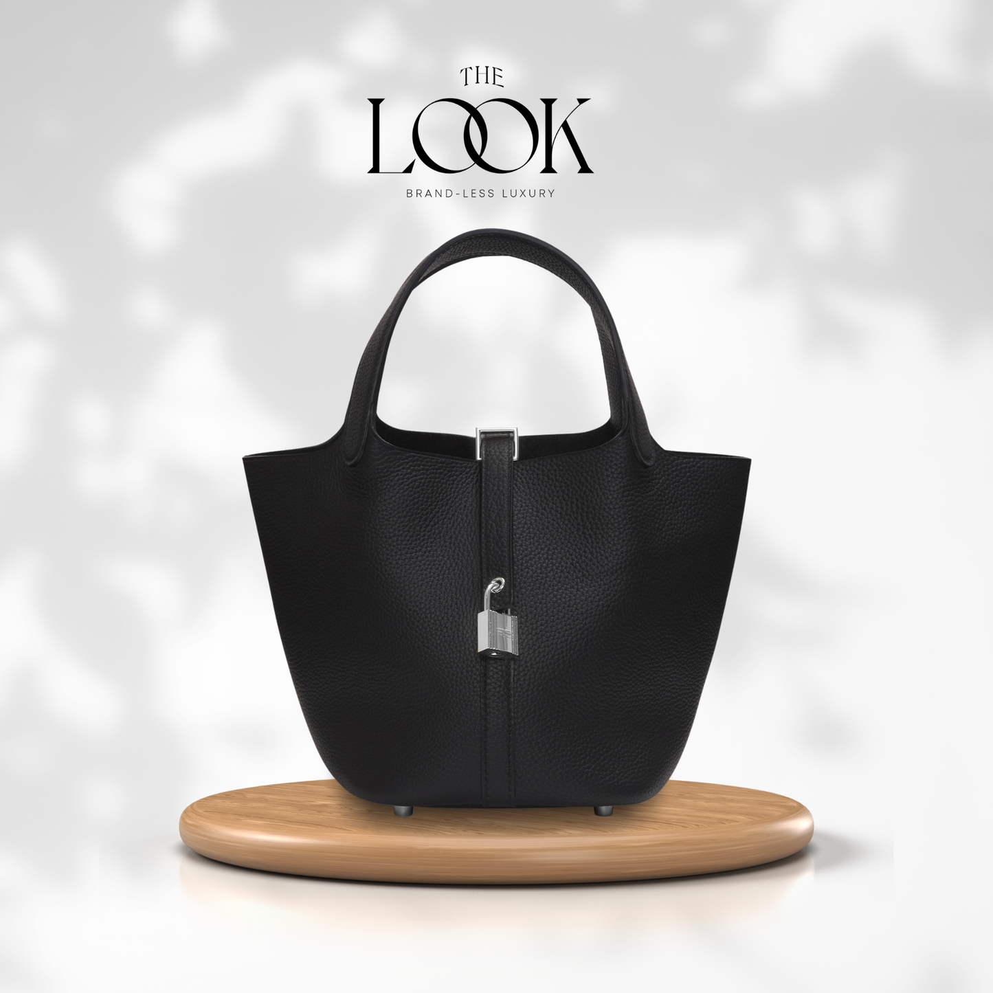 Black handbag on a wooden stand with 'The Look' branding on a light gray background | The Look Officiel