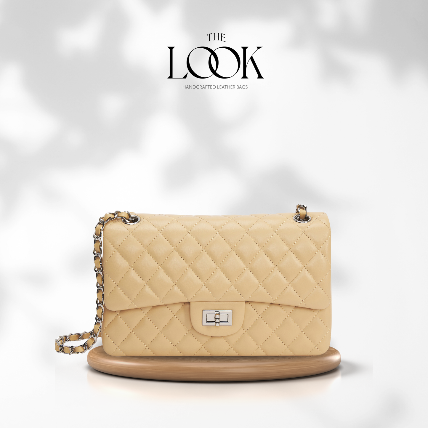 Beige quilted handbag with a chain strap on a white background, featuring 'The Look' brand. | The Look Officiel