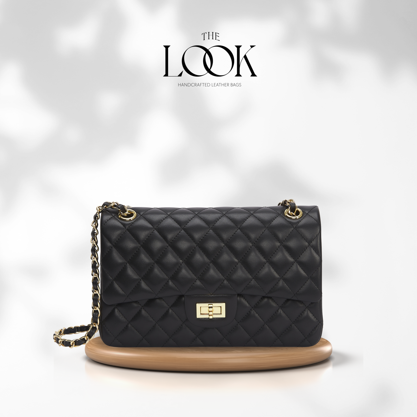 Black quilted handbag with gold accents on a white background, featuring 'The Look' brand. | The Look Officiel