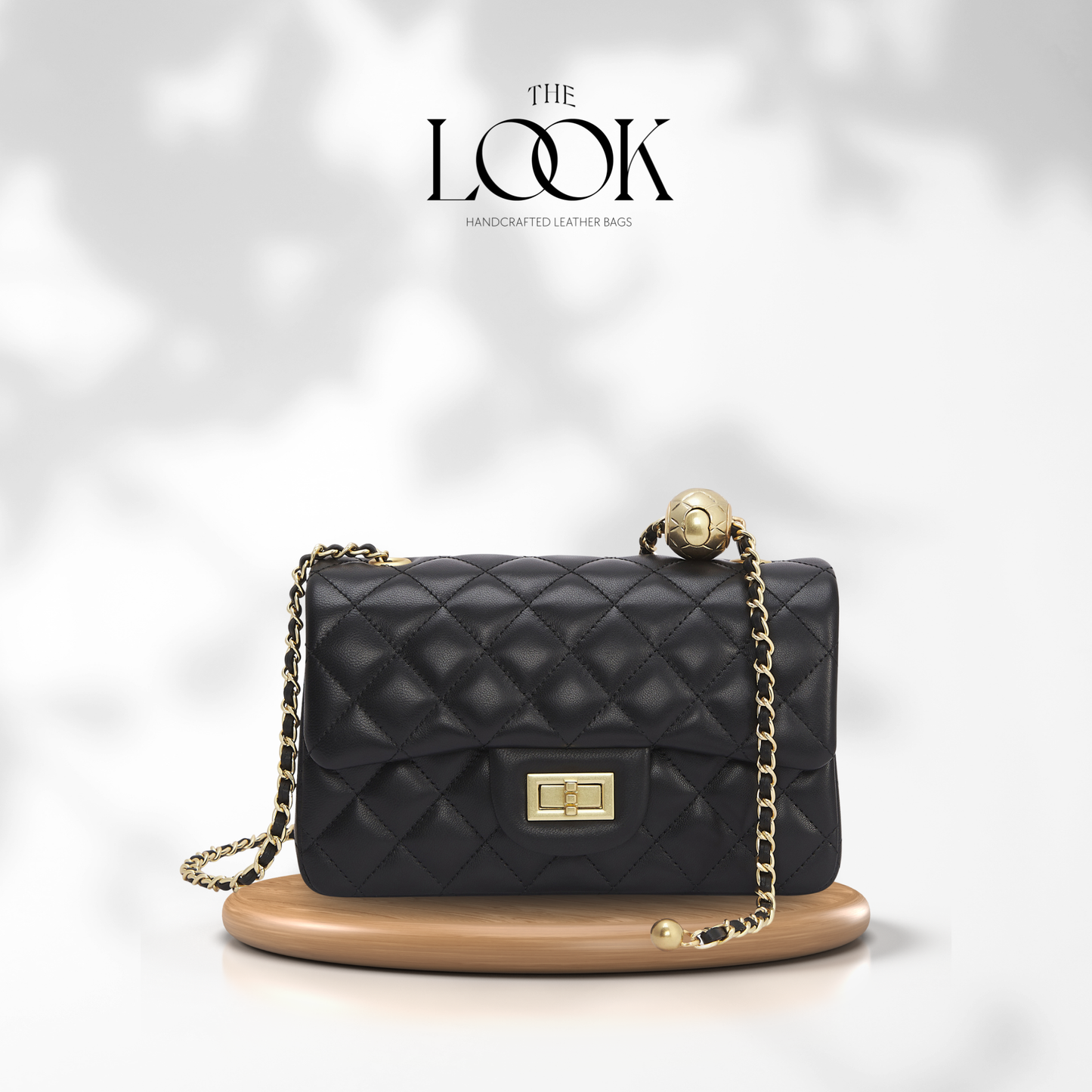 Black quilted handbag with gold chain on a white background, branded 'The Look'. | The Look Officiel