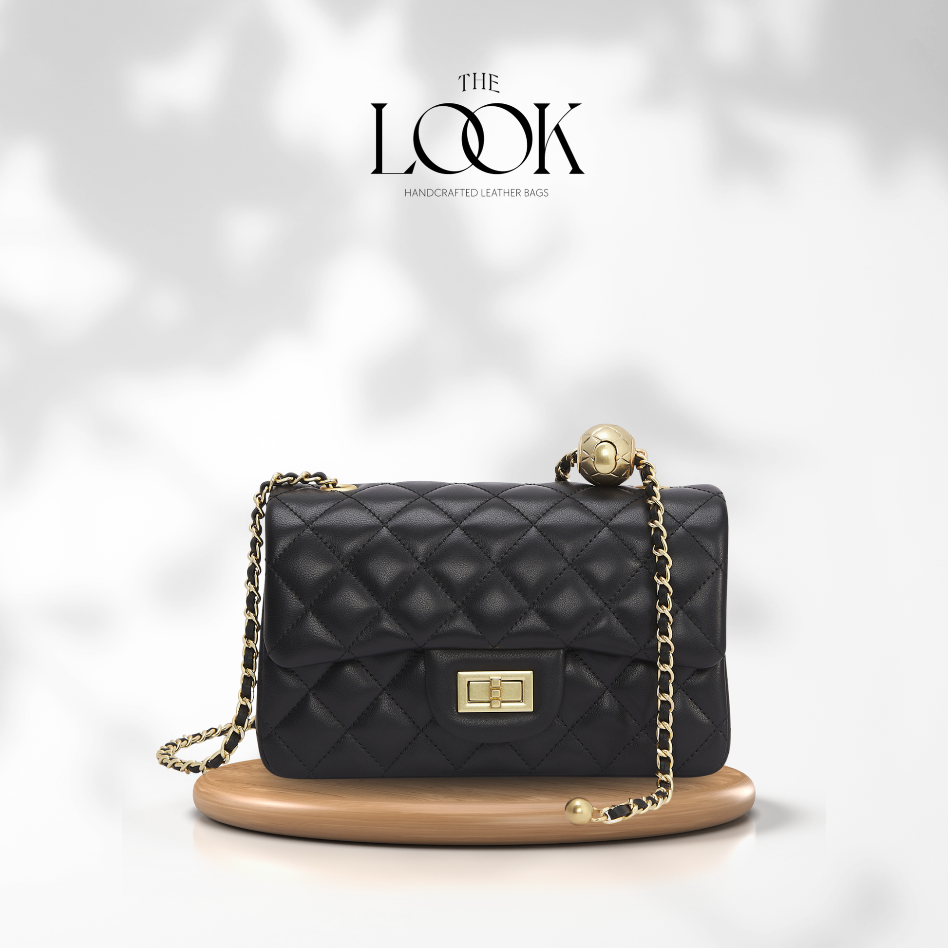 Black quilted handbag with gold chain on a white background, branded 'The Look'. | The Look Officiel