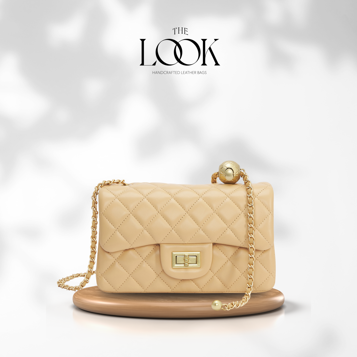 Beige quilted handbag with gold chain on a white background, branded 'The Look'. | The Look Officiel