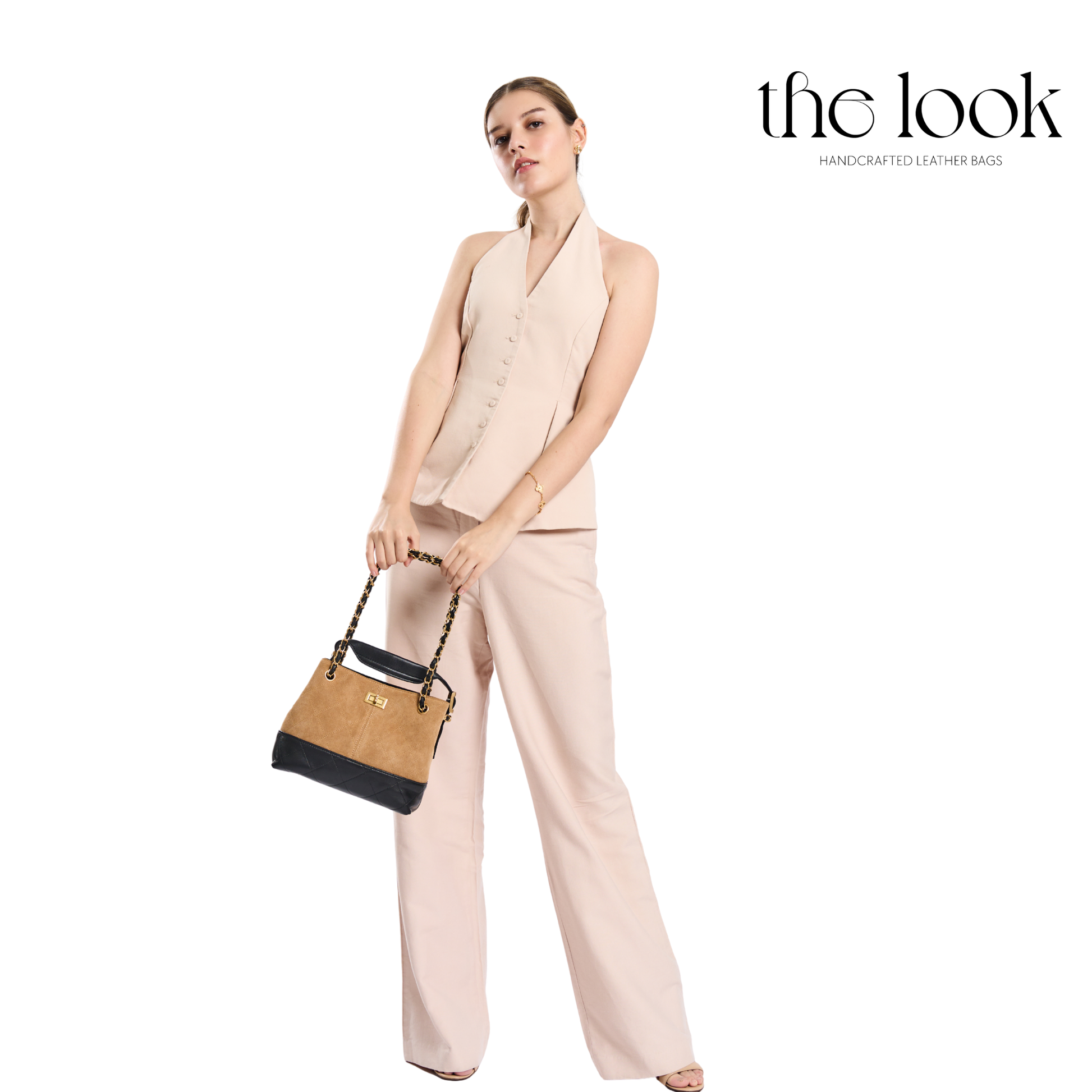 Woman holding a handbag with 'the look' branding on a white background. | The Look Officiel