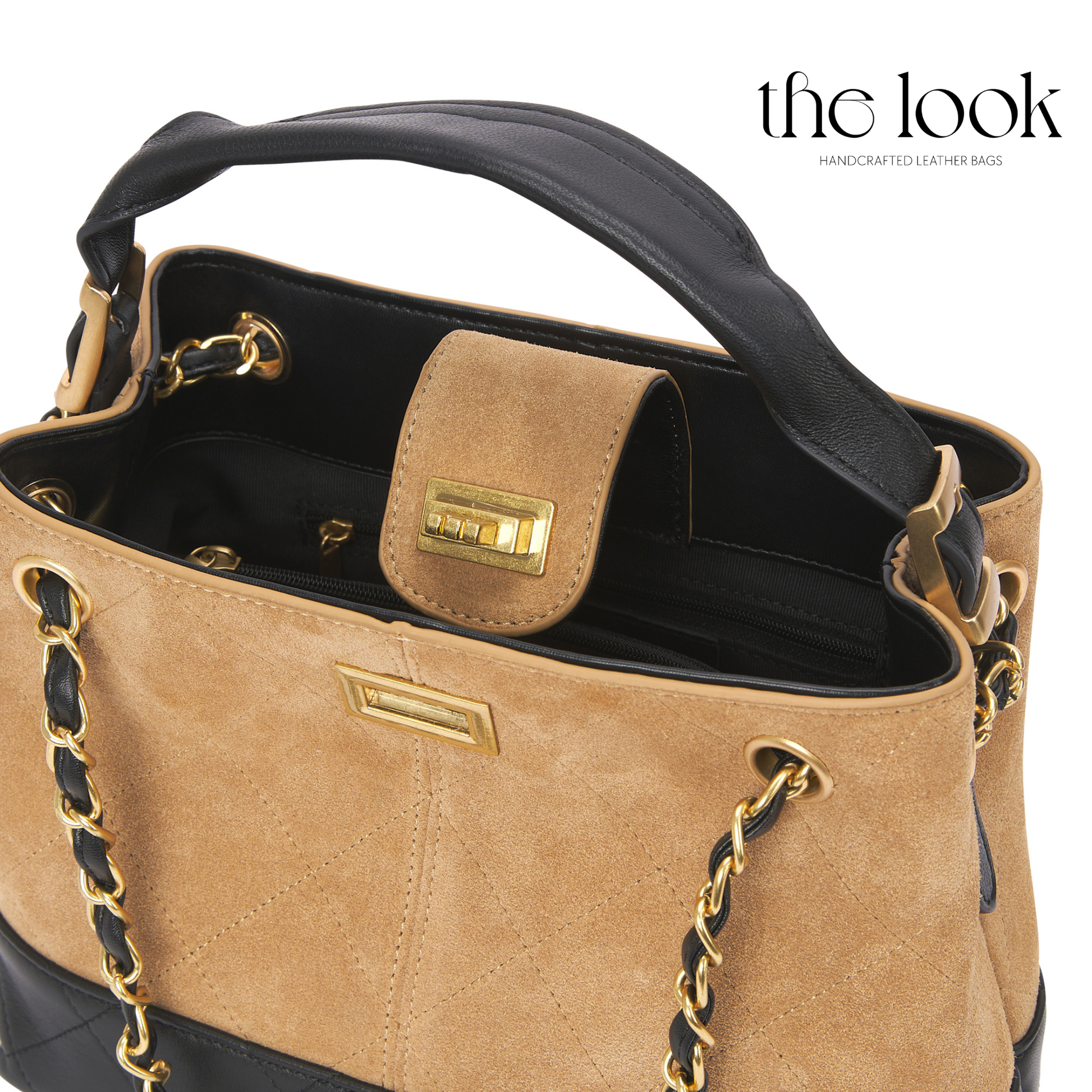 Tan handbag with black handle and gold accents on a white background. | The Look Officiel