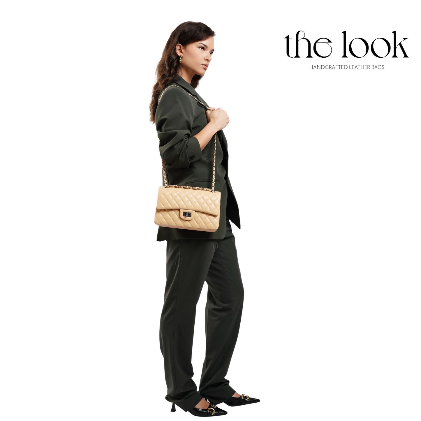 Woman holding a beige handbag with 'the look' branding on a white background. | The Look Officiel