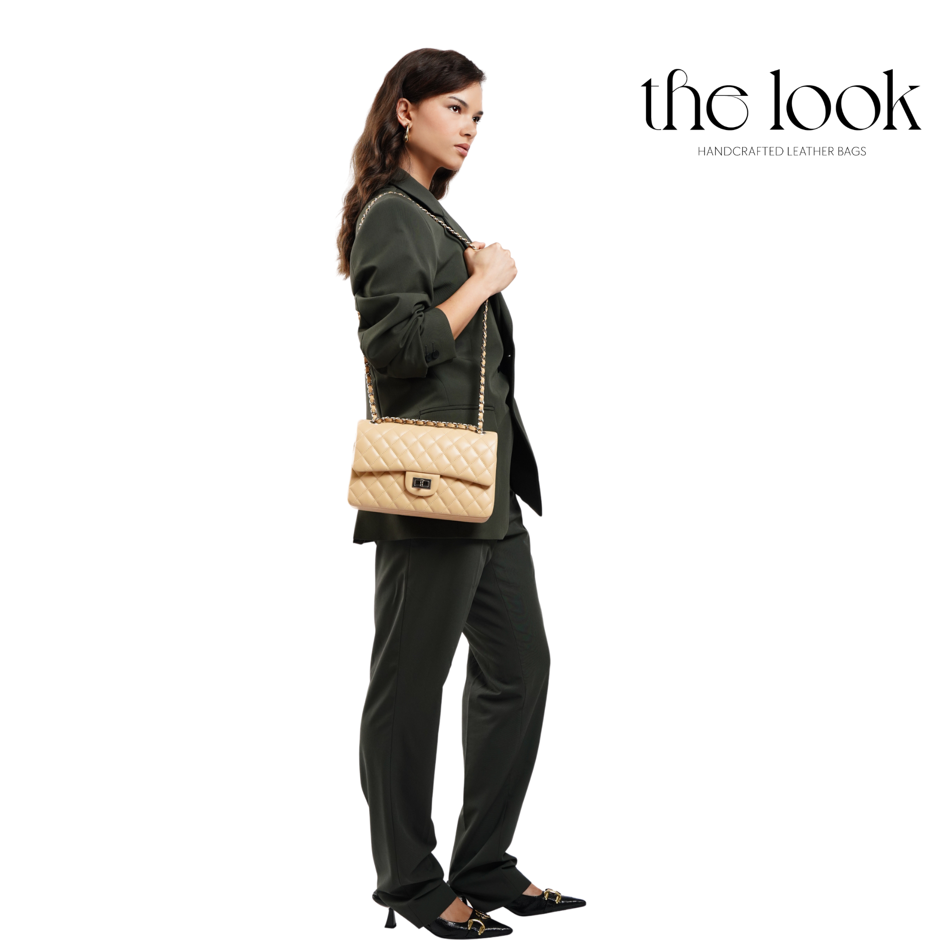 Woman holding a beige handbag with 'the look' branding on a white background. | The Look Officiel