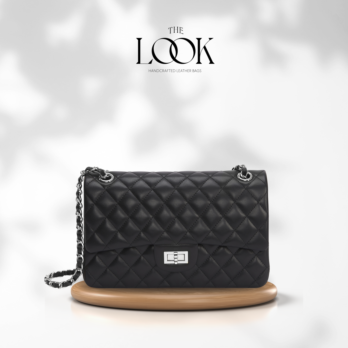 Black quilted handbag with chain strap on a white background, featuring 'The Look' brand. | The Look Officiel