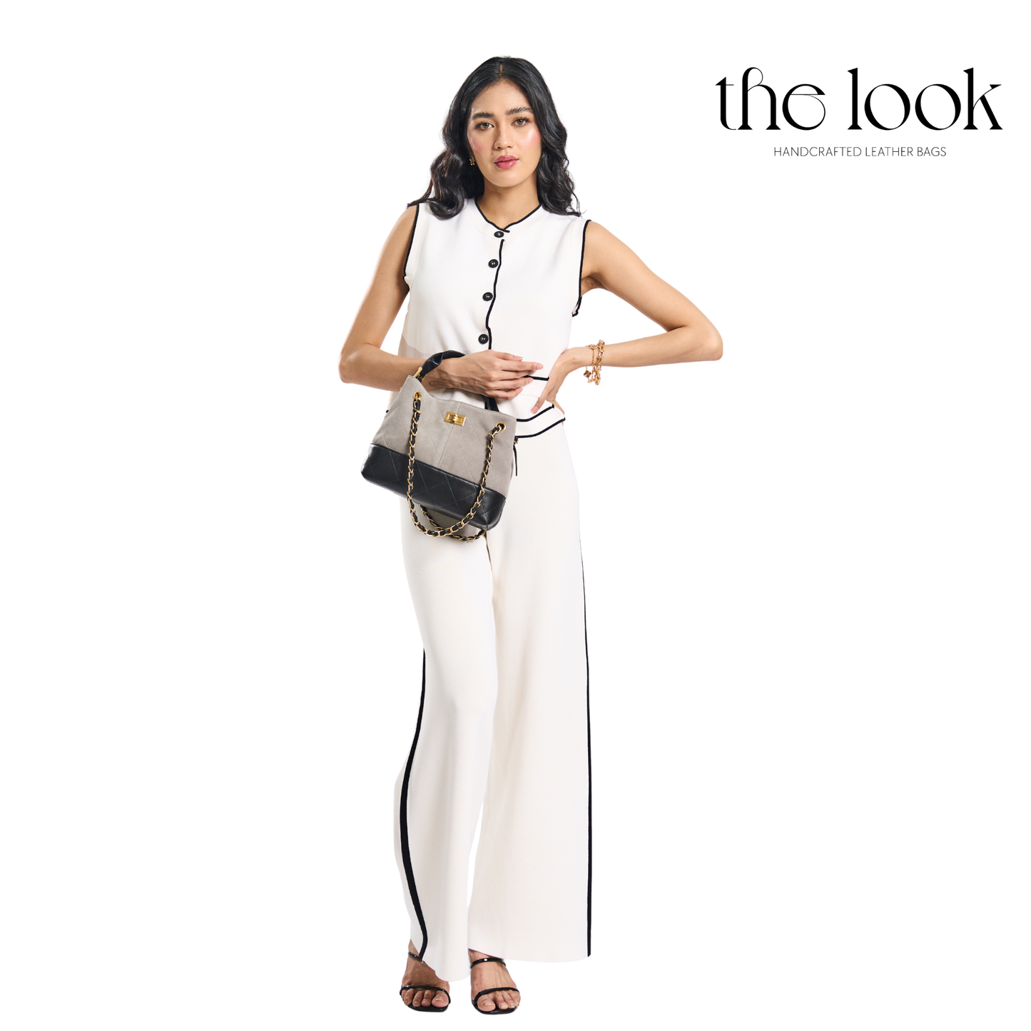 Woman in a white outfit holding a handbag with 'the look' branding on a white background. | The Look Officiel