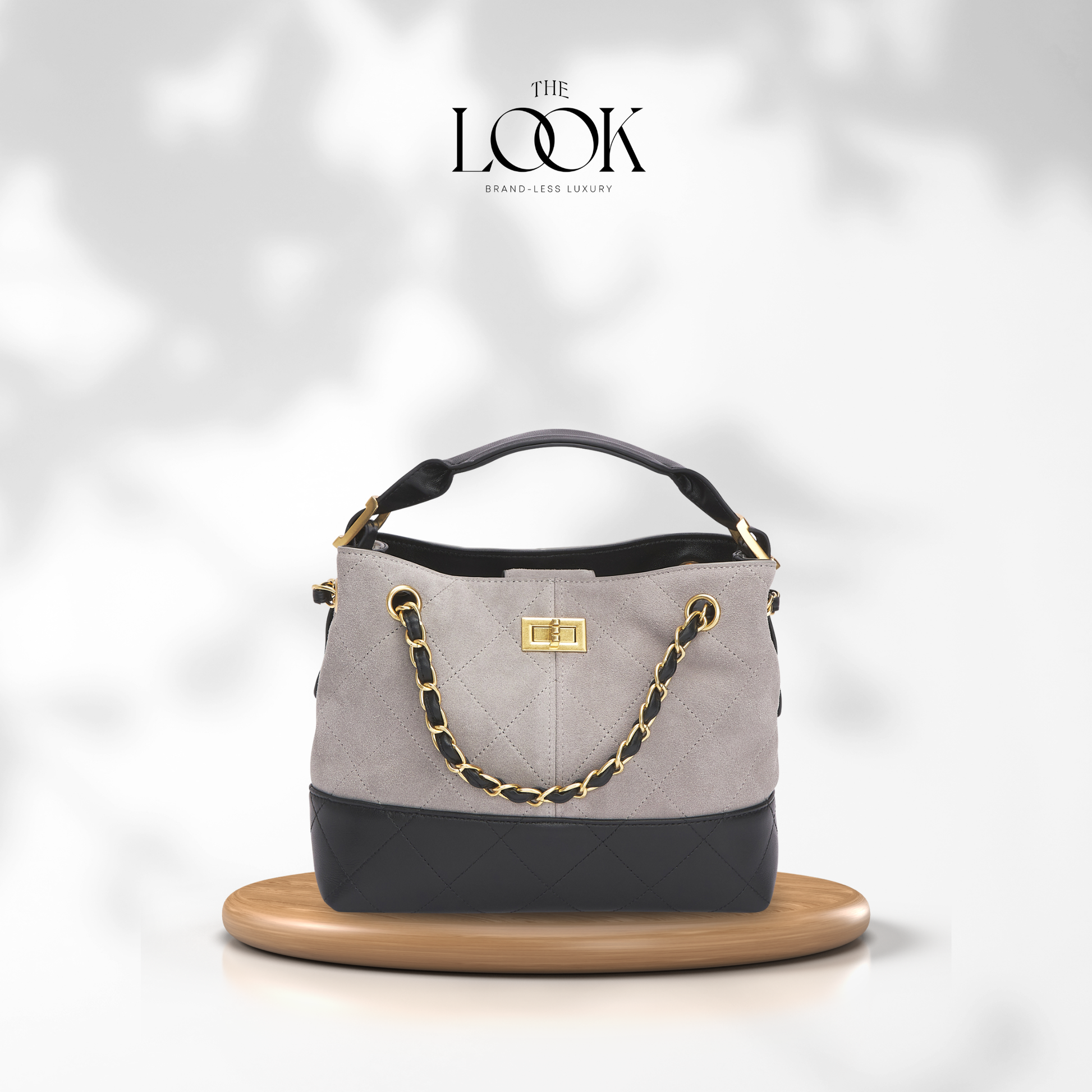 Gray handbag with black accents and gold chain on a white background, featuring 'The Look' brand. | The Look Officiel
