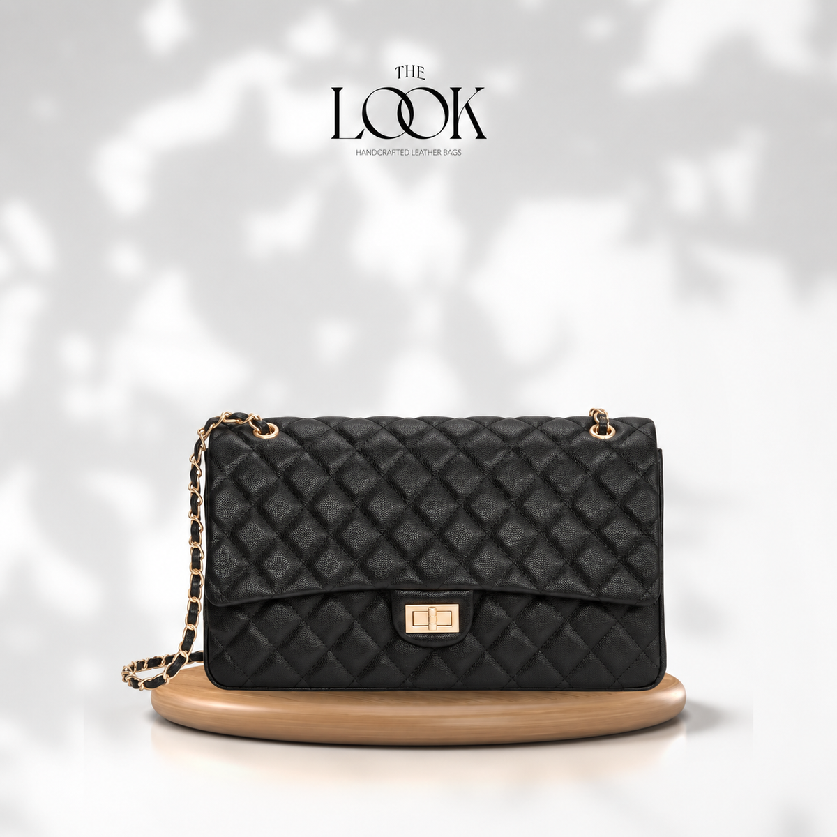 The Quilte Extra Large Convertible Shoulder Bag in Black with champagne gold hardware, front view | The Look Officiel