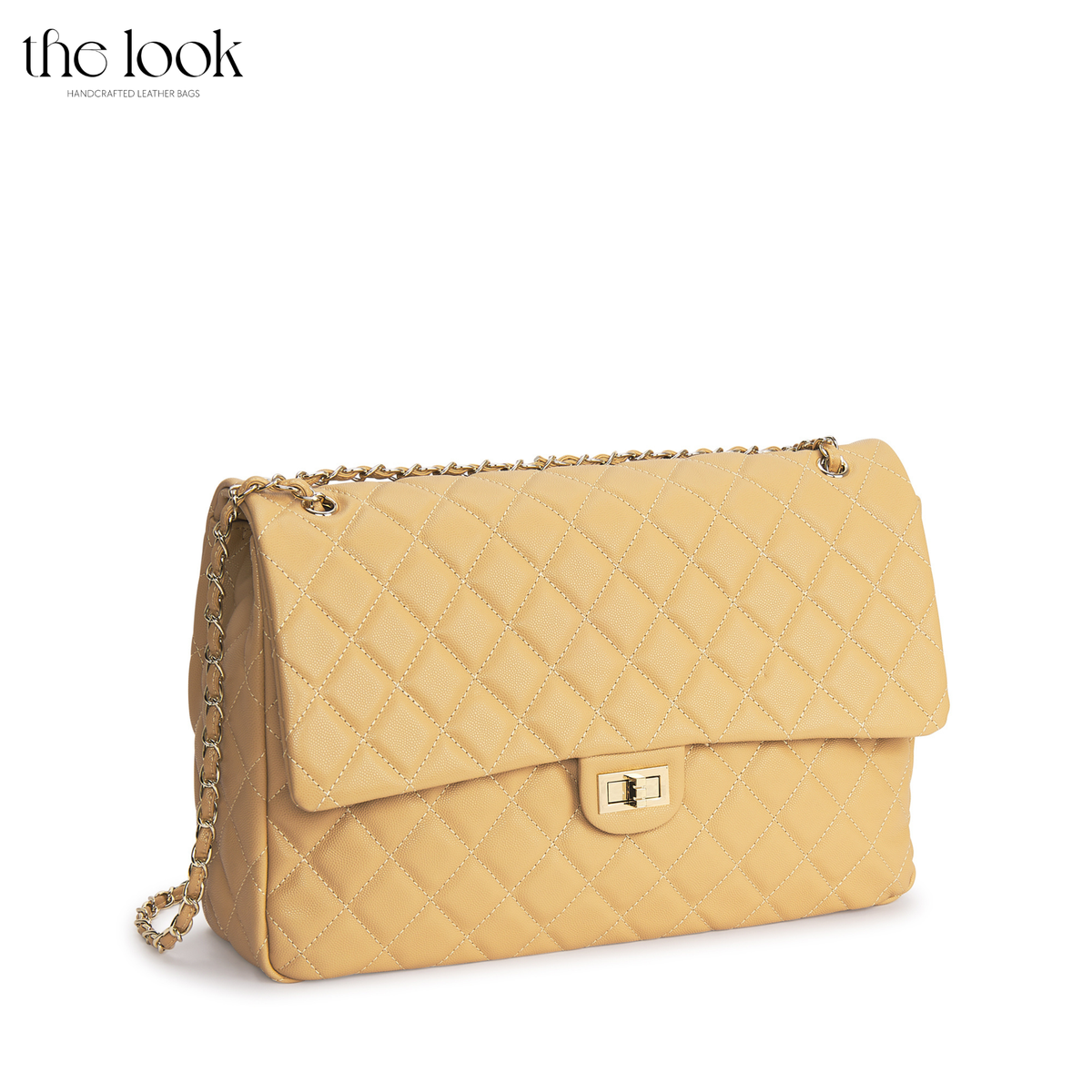 Biscuit The Quilte Jumbo Convertible Travel Bag with champagne gold hardware, angled front view | The Look Officiel
