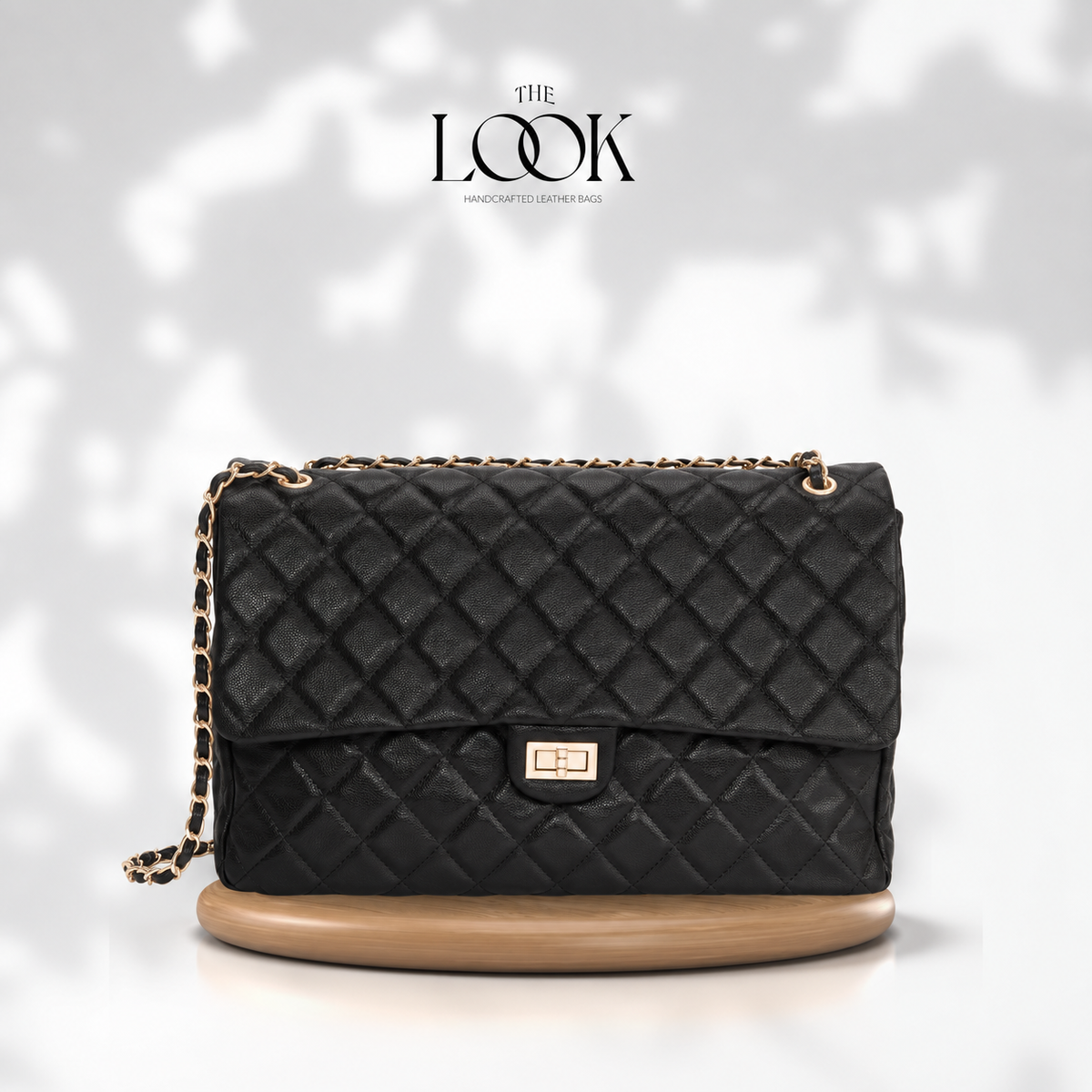 Black The Quilte Jumbo Convertible Travel Bag with champagne gold hardware, front view | The Look Officiel