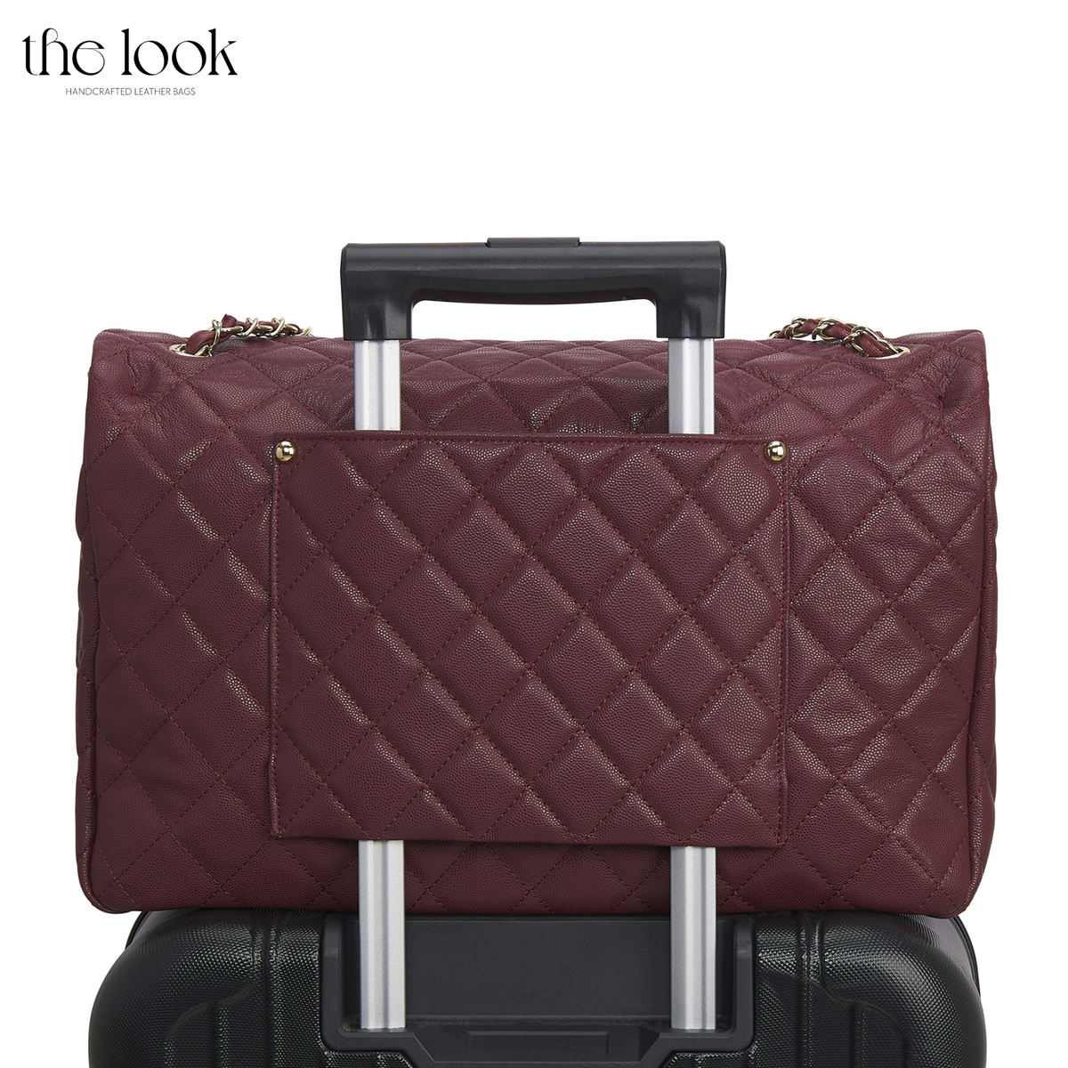 Burgundy The Quilte Jumbo Convertible Travel Bag secured over suitcase handle | The Look Officiel