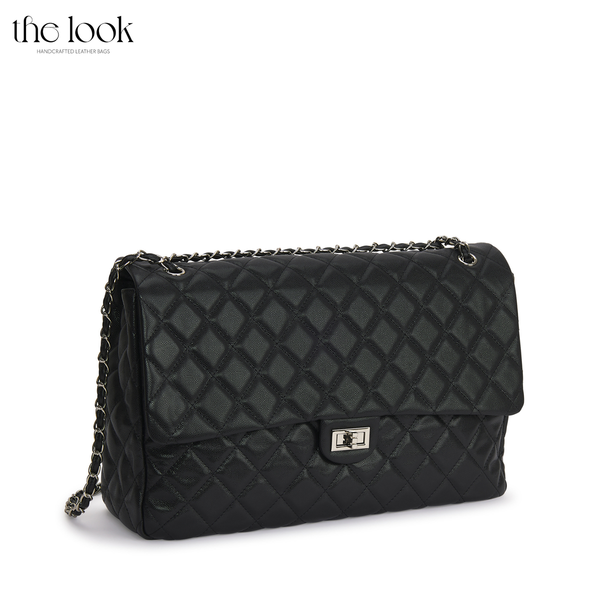 Black The Quilte Jumbo Convertible Travel Bag with silver hardware, angled front view | The Look Officiel