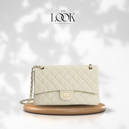 The Quilte Large Convertible Shoulder Bag in Cream with champagne gold hardware, angled front view | The Look Officiel