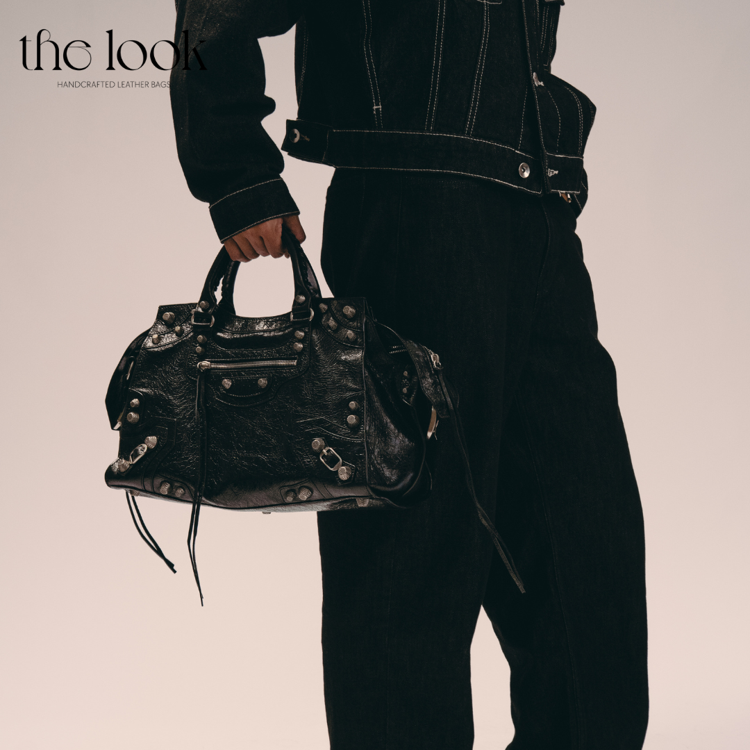 Model holding Biker Satchel Regular black goatskin braided handles gunmetal hardware front view