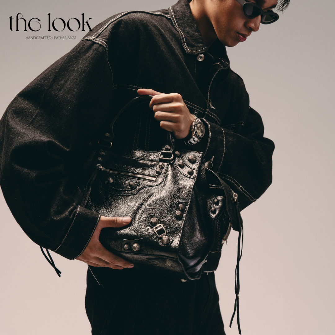 Model holding Biker Satchel Regular black goatskin braided handles gunmetal hardware front view