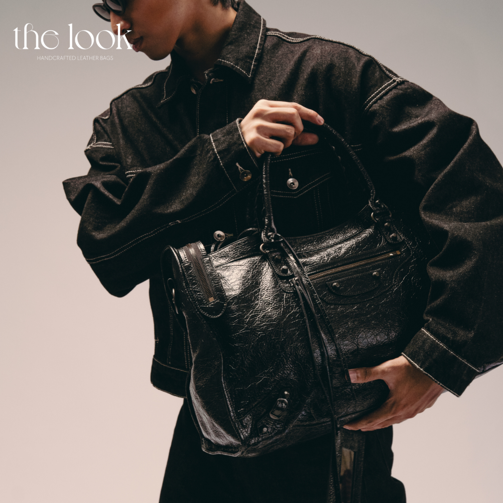 Model holding Biker Satchel Jumbo black goatskin braided handles front view gunmetal hardware