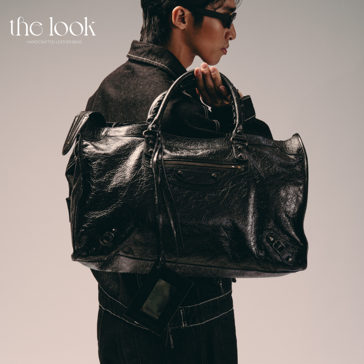 Model holding Biker Satchel Jumbo black goatskin braided handles front view