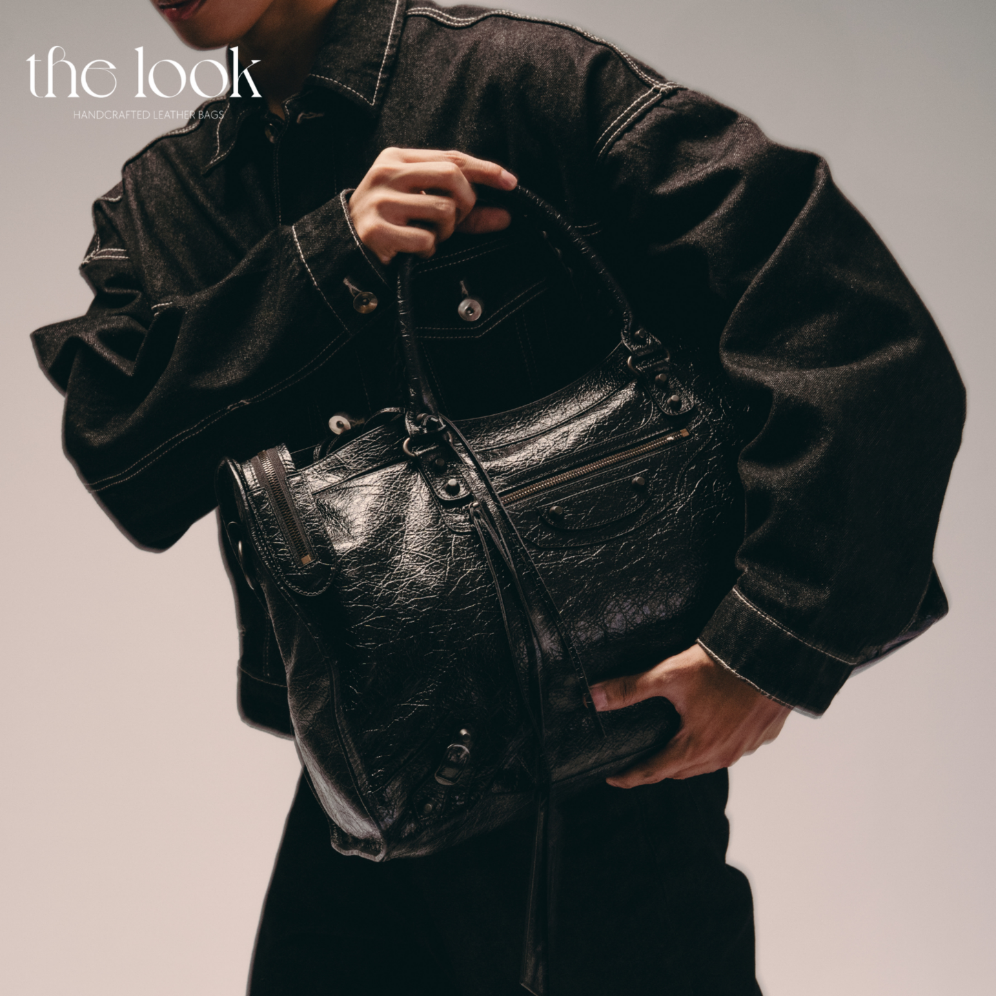 Model holding Biker Satchel Jumbo black goatskin braided handles front view