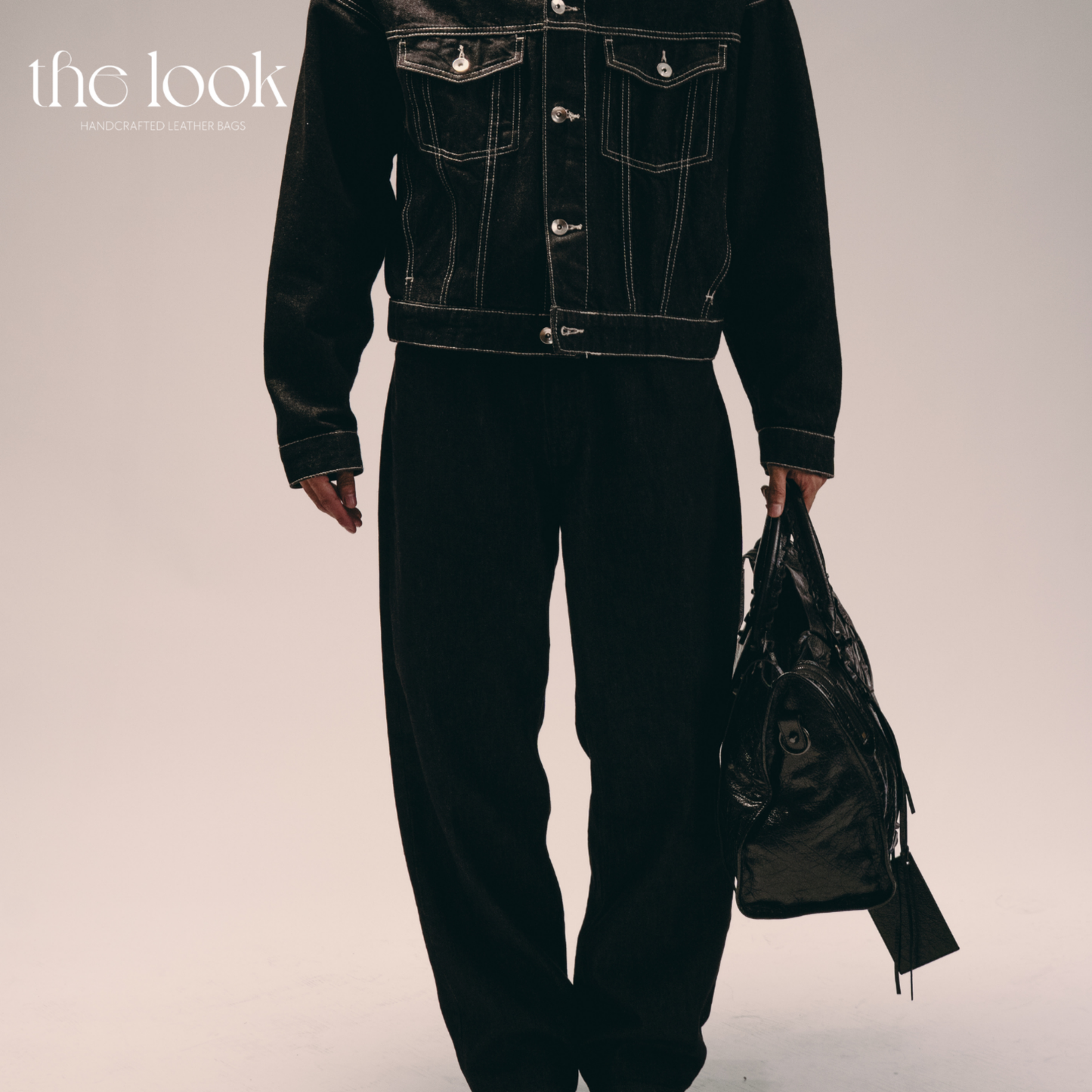 Model holding Biker Satchel Jumbo black goatskin braided handles side view gunmetal hardware