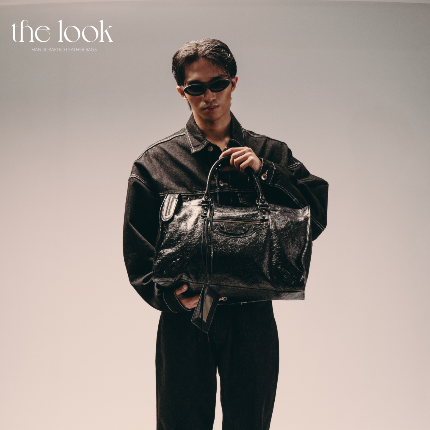 Model holding Biker Satchel Jumbo black goatskin braided handles front view gunmetal hardware