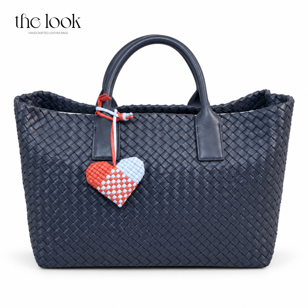 The Loop Amour woven leather heart bag charm in Cherry Sky on a navy woven tote