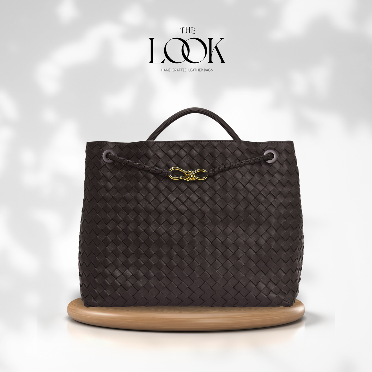 The Loop Jumbo Satchel in Ebene full-grain woven lambskin leather with top handle and gold hardware.