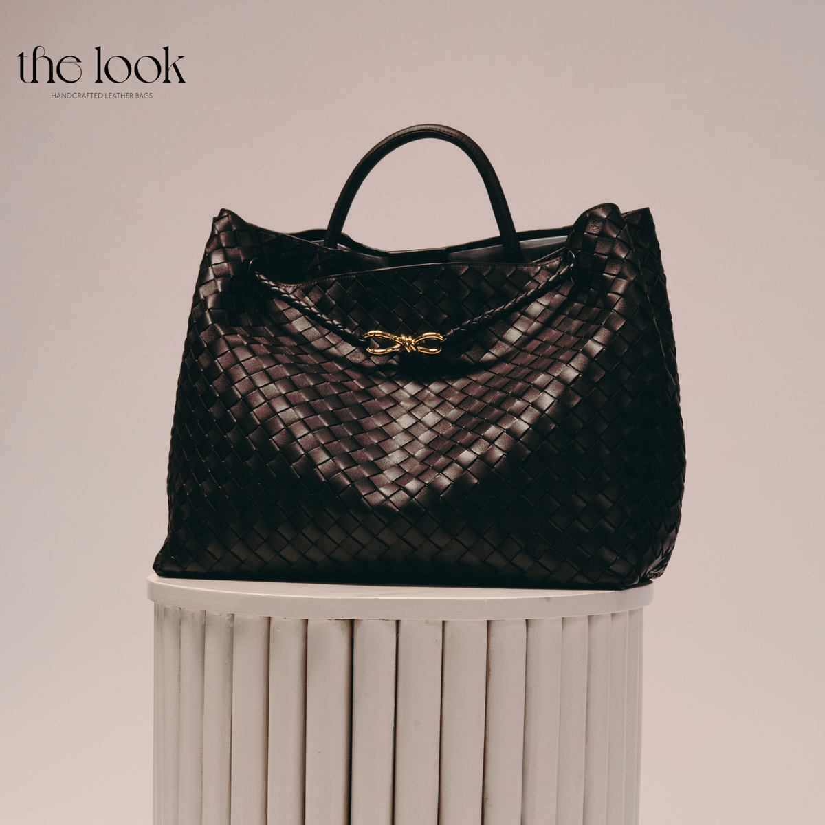 The Loop Jumbo Satchel in Ebene woven lambskin leather with top handle and gold hardware.