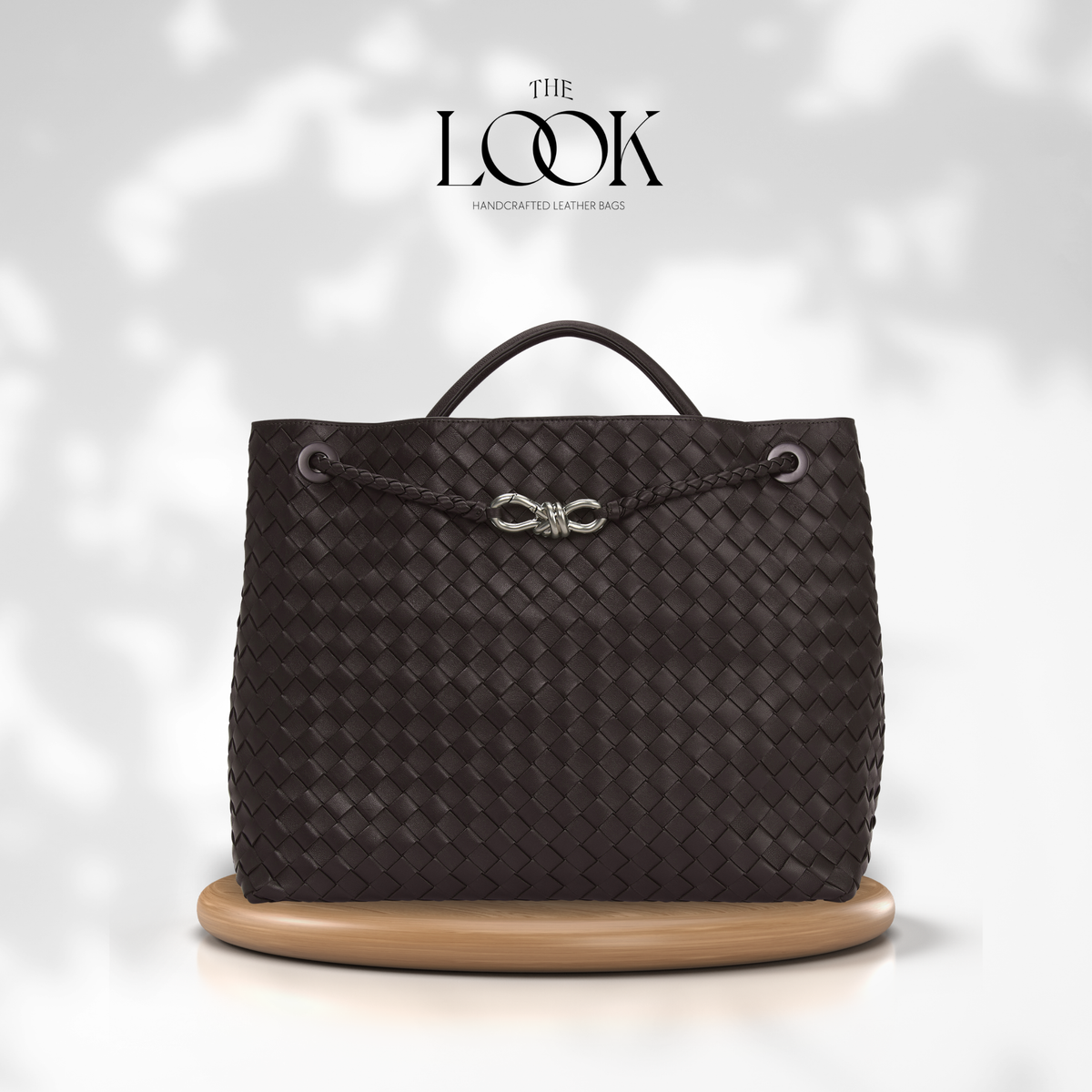The Loop Jumbo Satchel in Ebene woven leather with silver hardware and top handle, front view.