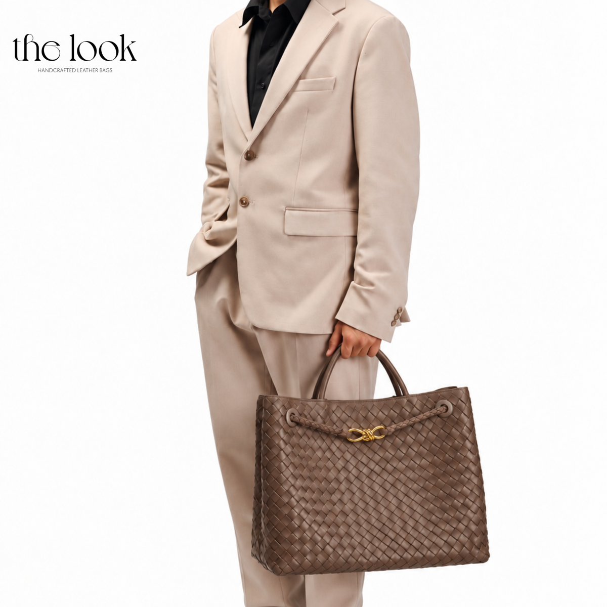 Model carrying The Loop Jumbo Satchel in Pinecone woven leather with gold hardware by the top handles.