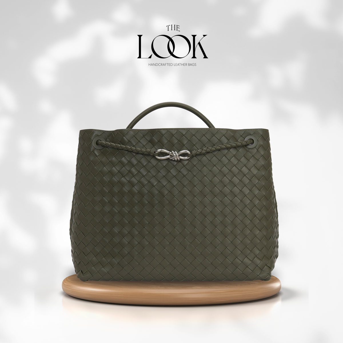 The Loop Jumbo Satchel in Olive full-grain woven lambskin leather with top handle and silver hardware.