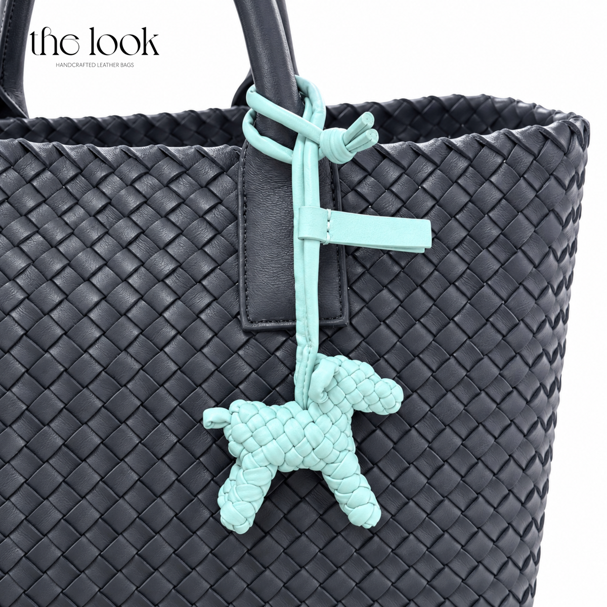 The Loop Pupper Bag Charm in Mint styled on a dark woven tote