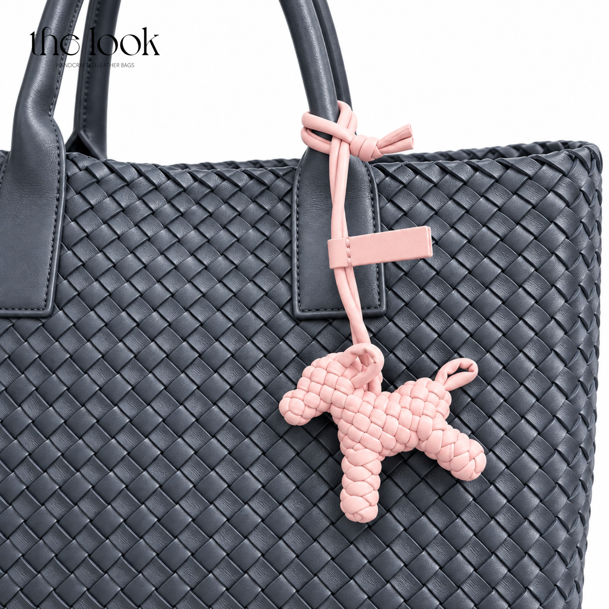 The Loop Pupper Bag Charm in Blush Pink styled on a dark woven tote
