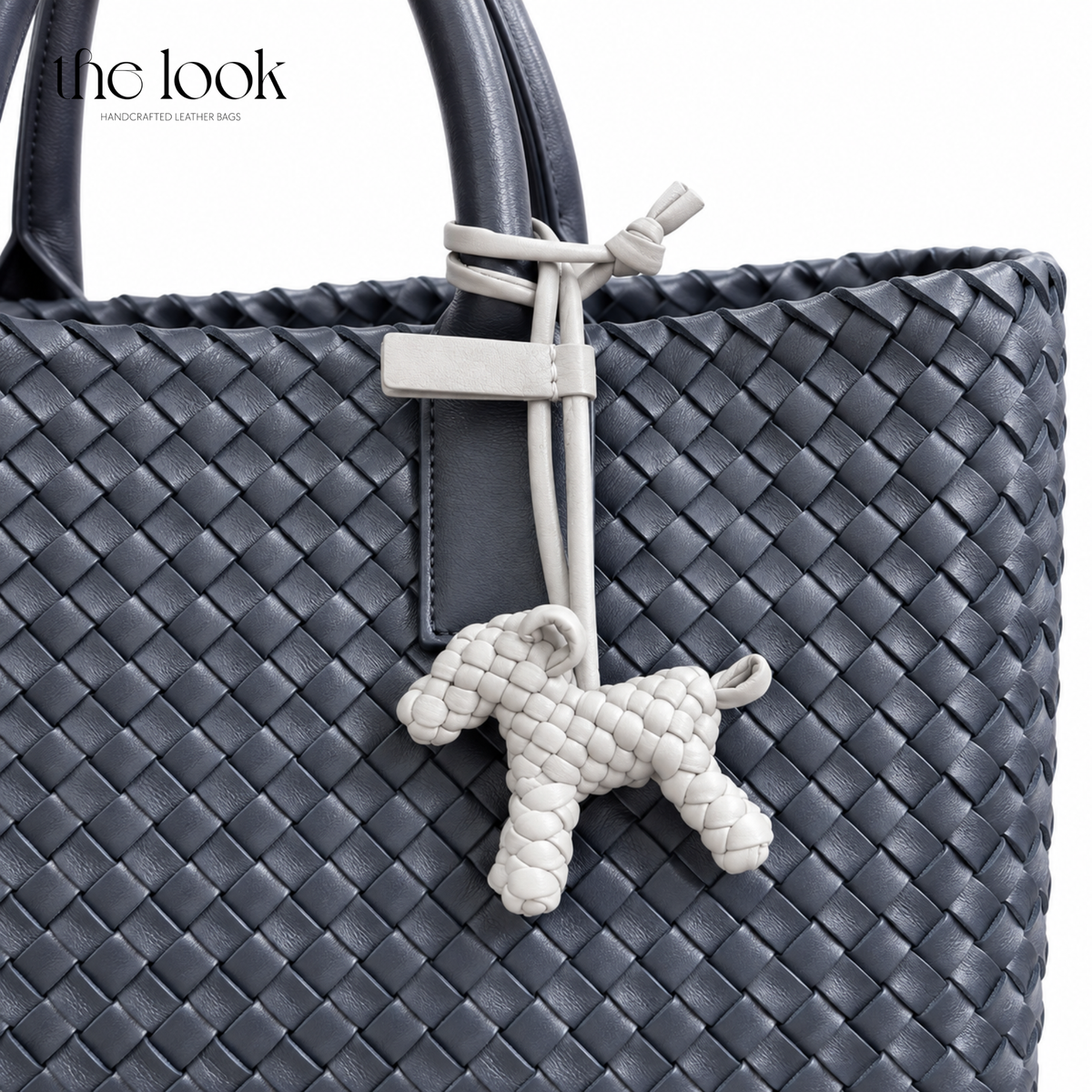 The Loop Pupper Bag Charm in Pearl Gray styled on a dark woven tote