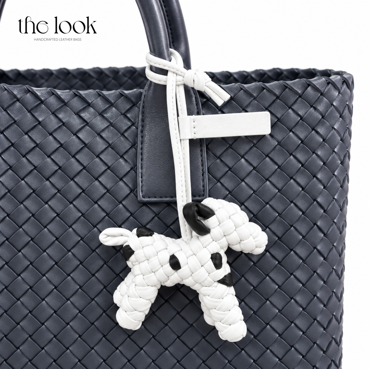 The Loop Pupper Bag Charm in Dalmatian styled on a dark woven tote
