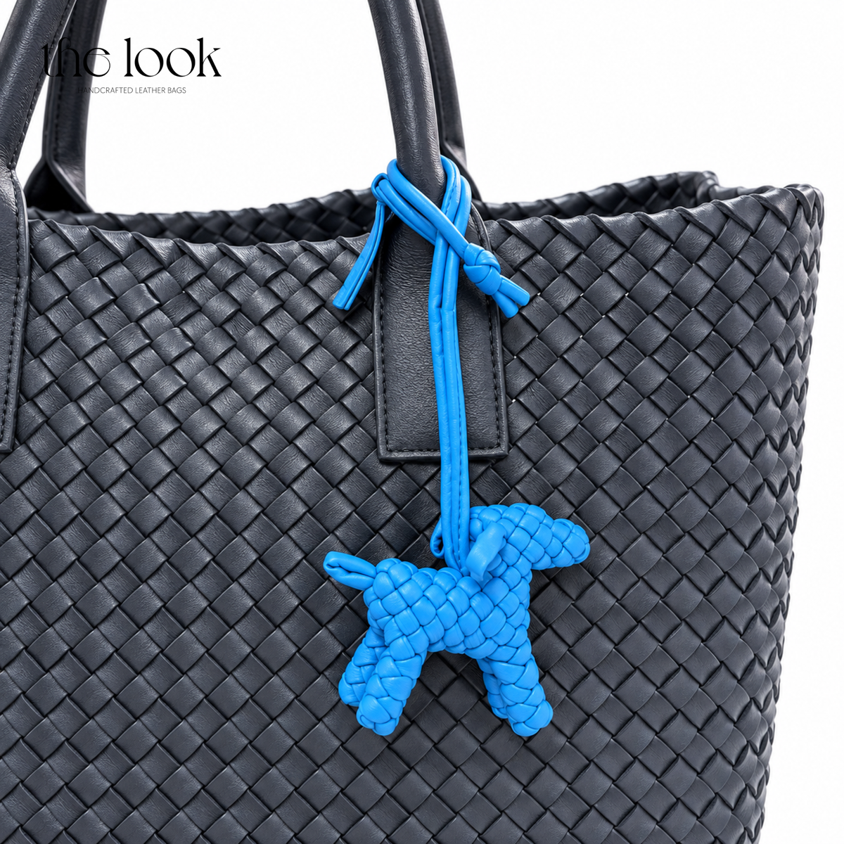 The Loop Pupper Bag Charm in Electric Blue styled on a dark woven tote
