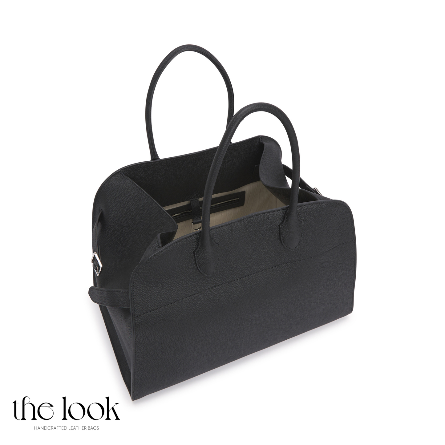 Black handbag with reflective surface on a white background, branded 'the look'. | The Look Officiel